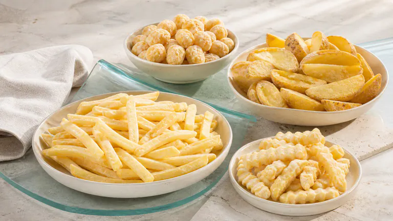 Golden frozen potato formats presented on a warm ivory surface